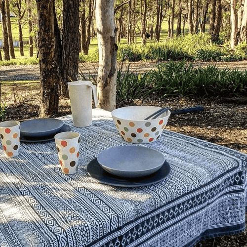 An outdoor table setting featuring Bamboo tableware in a charcoal and stone colour with spotty Salad bowl and bamboo cups to coordinate